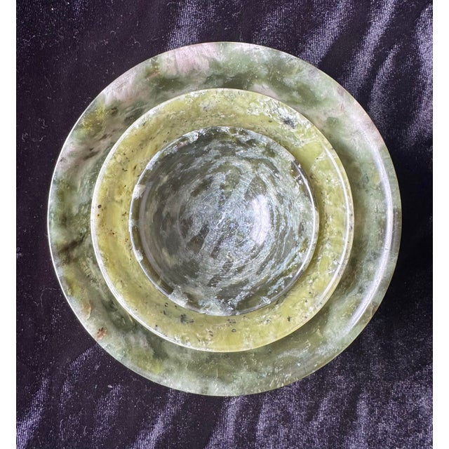 An exquisite set of three 20th-century Chinese nesting bowls, masterfully hand-carved from natural serpentine stone. These...