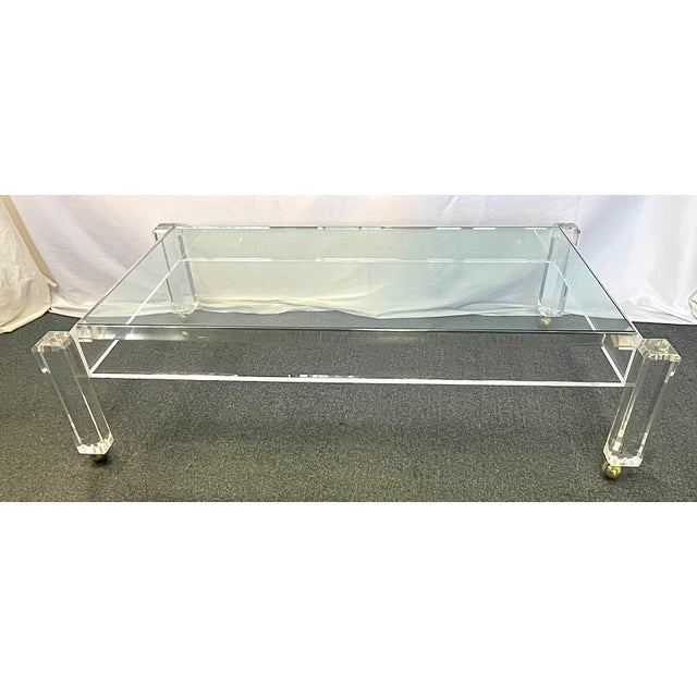 Glamorous vintage lucite and glass coffee table from the 1970s. The piece is designed in the style of Charles Hollis Jones...