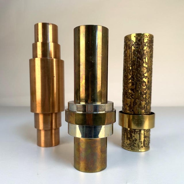 A striking trio of sculptural vases, each conceived of stacked cylindrical forms in contrasting metals and finishes are...