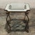 Mid-Century Hand Forged Wrought Iron and Frosted Glass End Table features graceful scrolls and concave mitered corners to...