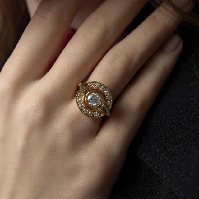 This vintage 1970’s ring highlights a luminous old European cut diamond complemented by fine F-color diamond accents, set...