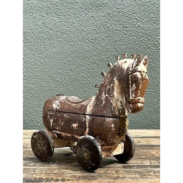 This exquisite hand-carved wooden Trojan horse serves as both a captivating sculpture and a functional decorative box....