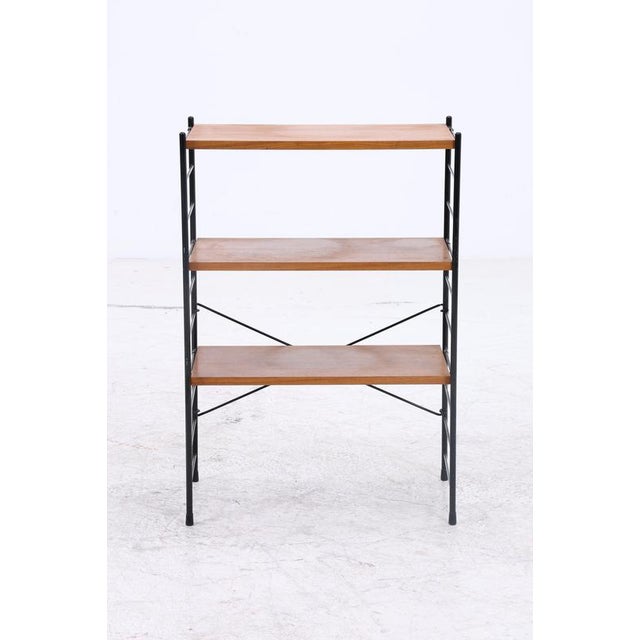The vintage string shelf combines a delicate black metal frame with three warm-toned wooden shelves. The open design...