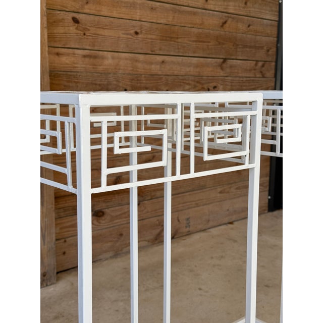 Striking pair of vintage Coastal Regency Greek Key plant stands, featuring a classic geometric fretwork design and slender...