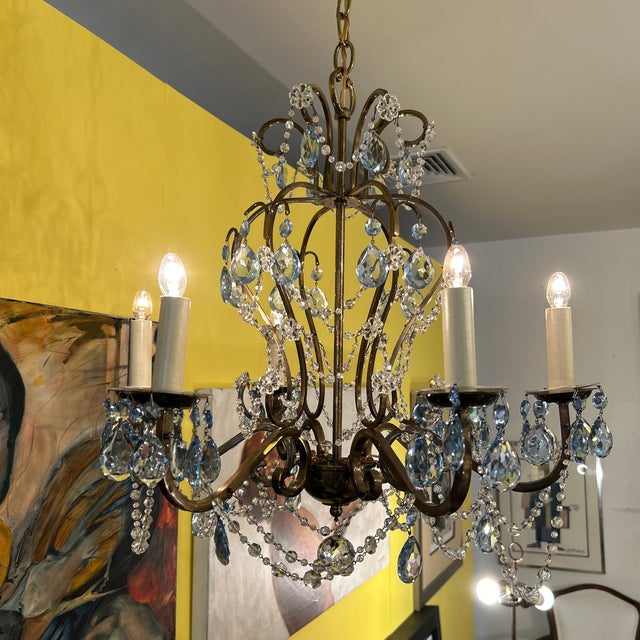 Elegant and curvaceous bronze finish iron chandelier with drop crystal pendants. The crystals swag between the arms and...