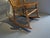 Beautiful vintage wooden rocking chair featuring a classic Windsor-inspired design with a detailed pressed-back ornate...