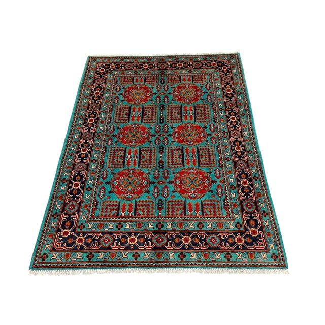 A vivid turquoise field brings this wool rug’s repeating geometric Tree of Life design into focus. Red medallions,...