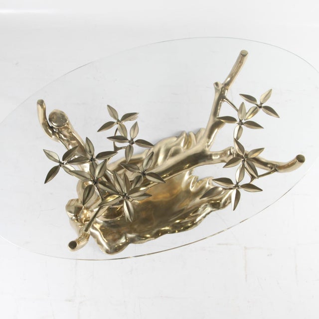 Beautiful polished brass bonsaï coffee table attributed to Willy Daro with a thick glass top. Very decorative, excellent...