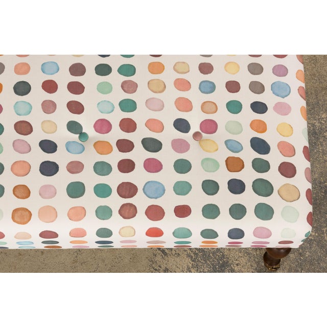 A refined vintage French country ottoman featuring a classic rectangular form set on turned wooden legs with original...