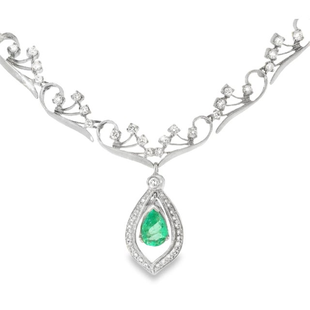 Antique 14K white gold filigree necklace featuring a pear-shaped emerald 7 x 11 mm, 2 carats as the centerpiece. Accented...