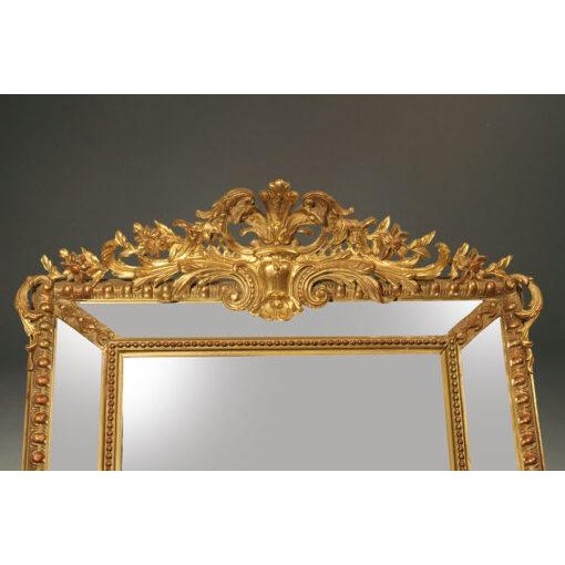 Exceptional 19th-century French Louis XVI-style gilded mirror, dating to circa 1840–1850. Featuring an ornate frame with a...