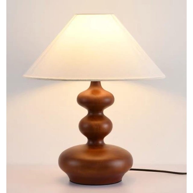 Milk-white linen fabric shade (soft light transmission), walnut wood-textured rounded lamp body. Warm light through fabric...