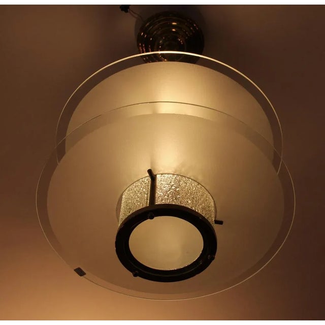 This type of Deco Lüster/Lantern made of brass lights up from a cylinder made of heavily relieved glass regents, which is...