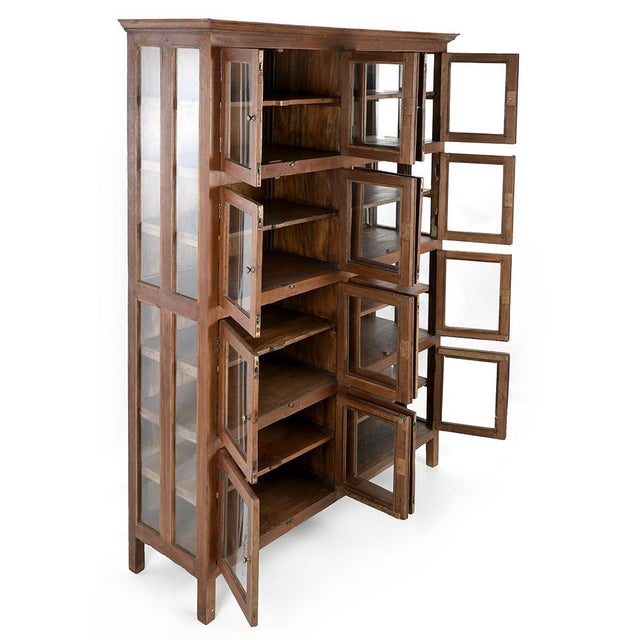 This solid wood glazed cabinet, equipped with 8 compartments each opening via 2 glass doors (i.e. 16 doors and storage...
