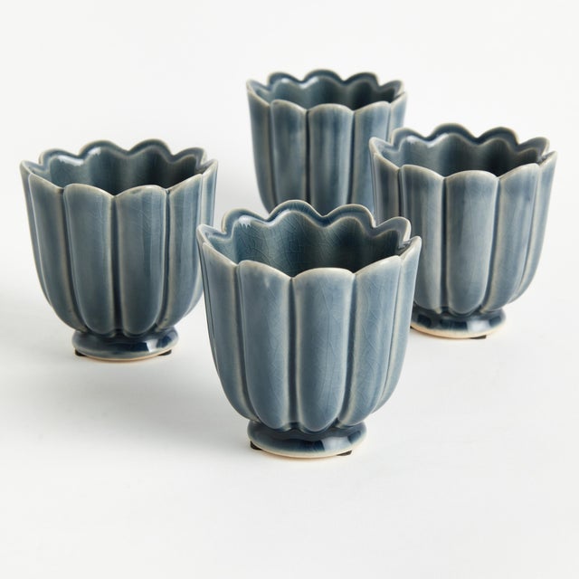 In a classic silhouette with petal edges, these footed mini pots are natureinspired. Finished in a rich teal reactive...