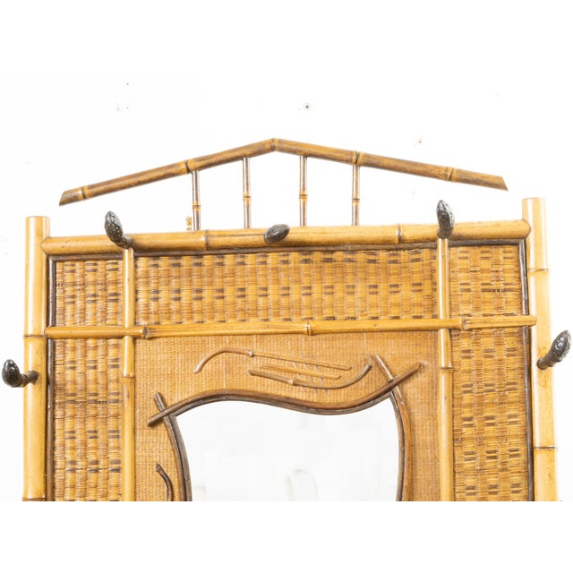An English bamboo and rattan hat rack from the late 19th century, with mirror and tiles. Created in England during the...