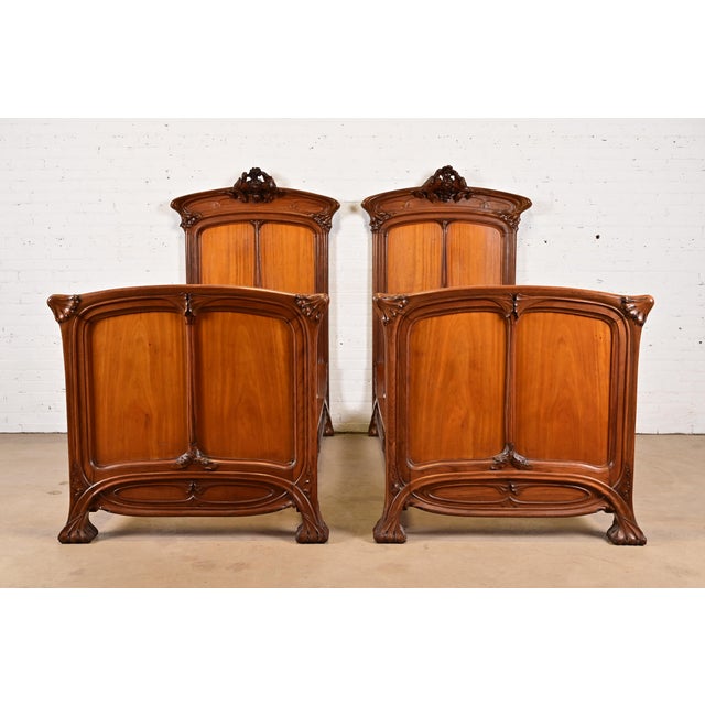 A gorgeous pair of antique French Art Nouveau period carved walnut twin size beds Attributed to Louis Majorelle France,...