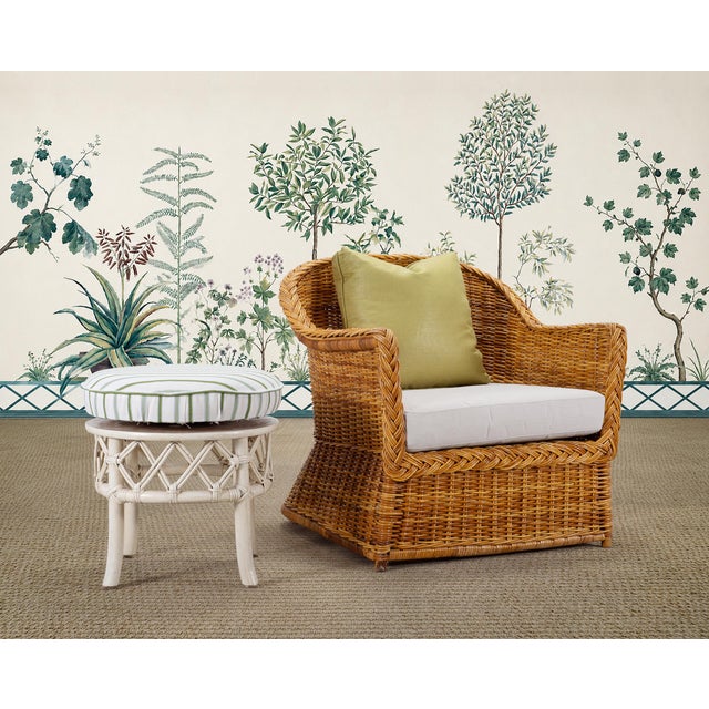 A charming round stool or ottoman crafted out of rattan with woven wicker joinery made by Ficks Reed, Cincinnati, Ohio....