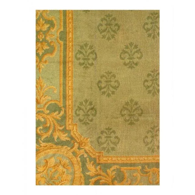 Donegal antique rug, having a leafy green vinery trellis overall within a light green border with leaves in green and Gold...