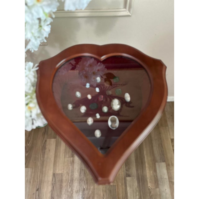 Elegant heart-shaped accent table from the Fabergé Heirloom Furniture Collection, featuring a glass inset top, warm...