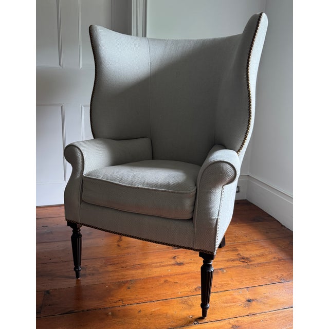 Make a commanding statement with this striking, high-back Hepplewhite-style wing armchair. Showcasing an elegant,...
