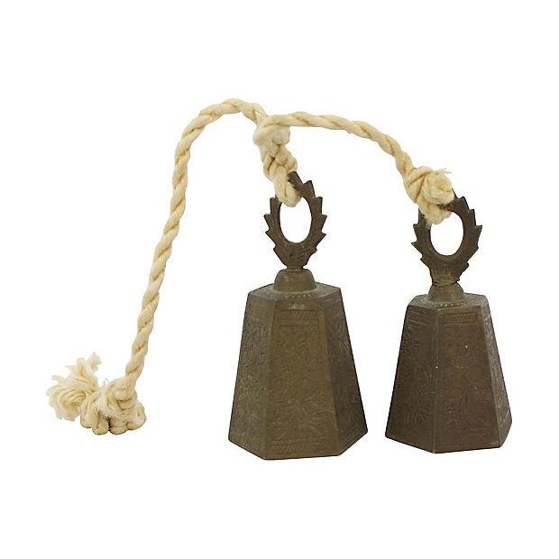 Pair of engraved brass bells on rope. Made in India. Light tarnish. Smaller bell, 2"Dia x 3.5"H.