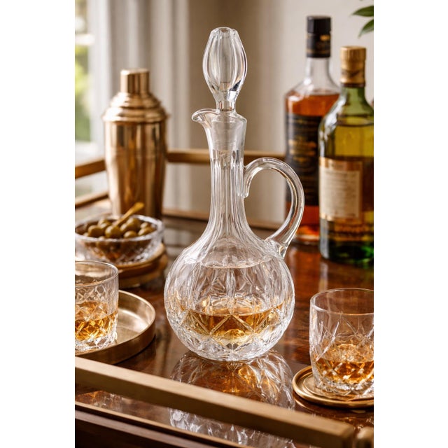 This elegant handled crystal decanter features classic European styling with a rounded body, deep starburst cut detailing,...