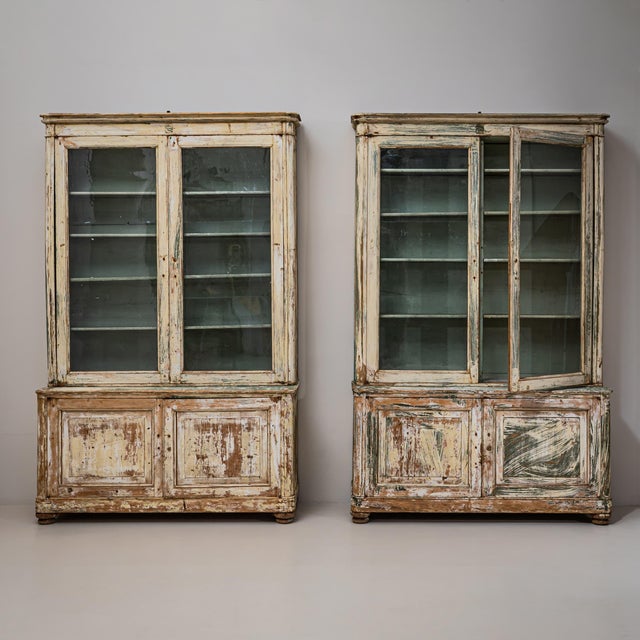 Pair of substantial bookcases with two-door lower sections and glazed two-door uppers fitted with adjustable shelves. The...