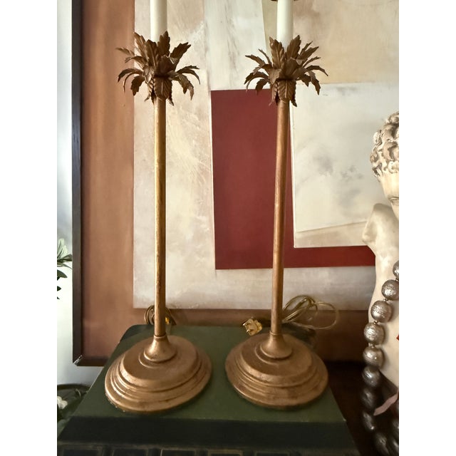 A sculptural and quietly dramatic pair of table lamps by Currey and Company, featuring a warm antiqued gold finish and a...
