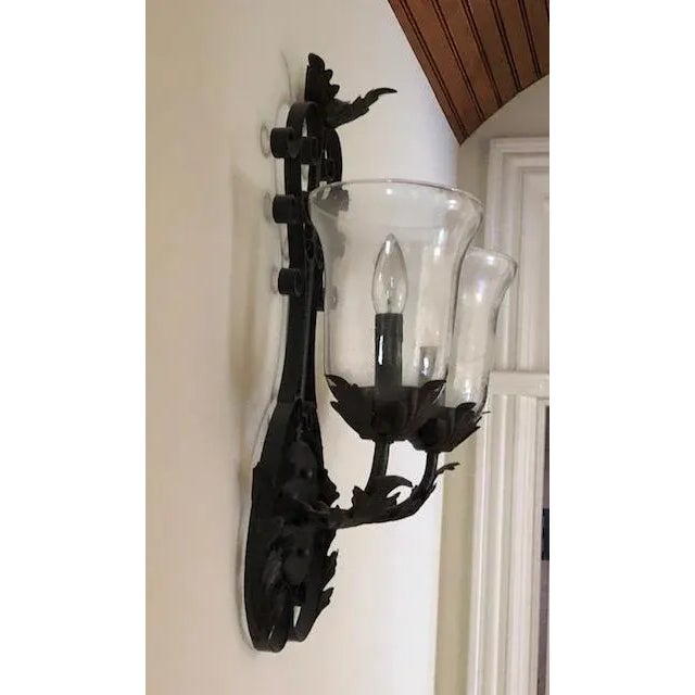 Iron wall sconce with two lights. Tuscan influenced with seeded glass. Allows up to 60 watt bulbs. No imperfections noted.
