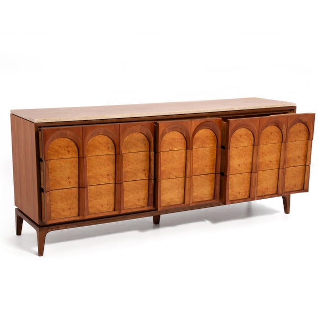 An "Arched" series nine drawer dresser by Thomasville. The dresser features a solid wood frame, walnut and burlwood veneer...