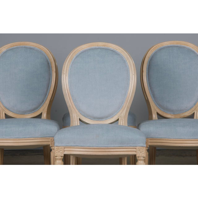 An elegant set of six French dining chairs in the Louis XVI style, sourced from Provence, France. Each chair features a...