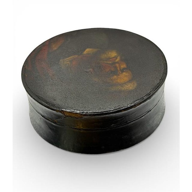 Small, moody, and ridiculously good on a desk. This antique round lacquer snuff box features a hand-painted male portrait...