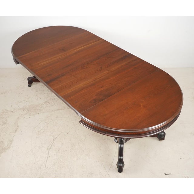 Victorian style round dark toned walnut table with a turned pedestal column and four carved splay legs. The table can be...