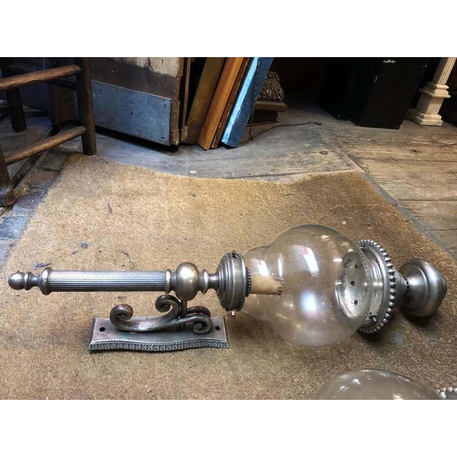 A gorgeous pair of lanterns, nickel-plated, 20th century. This fine pair have glass globe boles and are over 2 feet tall....