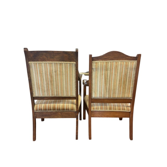 An elegant set of two antique American Empire walnut armchairs dating to approximately the mid-19th century. These...