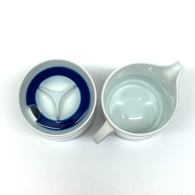 This vintage, delicate porcelain sugar bowl and creamer set, from Thomas Germany, features a classic white base accented...