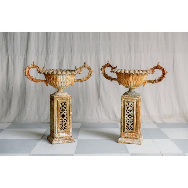 This exquisite pair of early 19th-century iron urns and stands showcases timeless craftsmanship. Originally finished in...