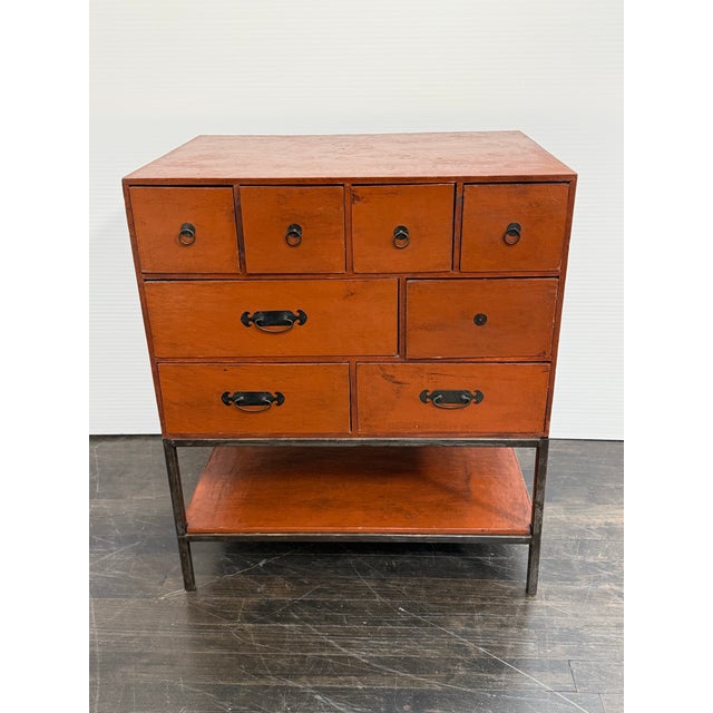 Design Plus Gallery presents a Vintage Asian Influenced Orange Lacquered Drawer Chest. This vintage chest has an orange...