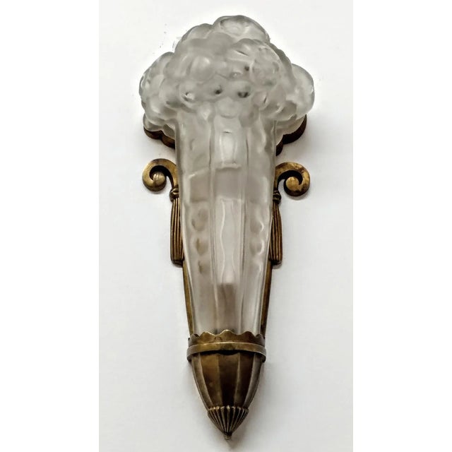 A French Art Deco wall sconce by the French artist "Genet et Michon" in clear frosted molded glass shades with floral...