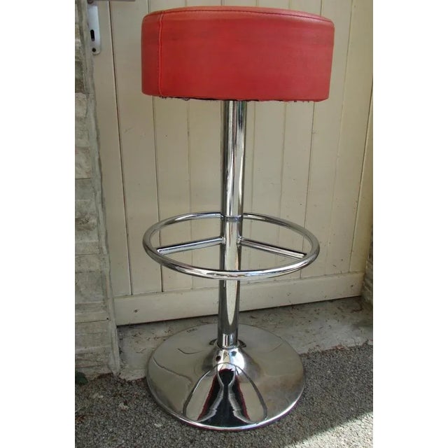 Pair of high, swivel stools, in chromed metal, Vega brand: specialist in bar stools, seat in red-orange imitation leather,...