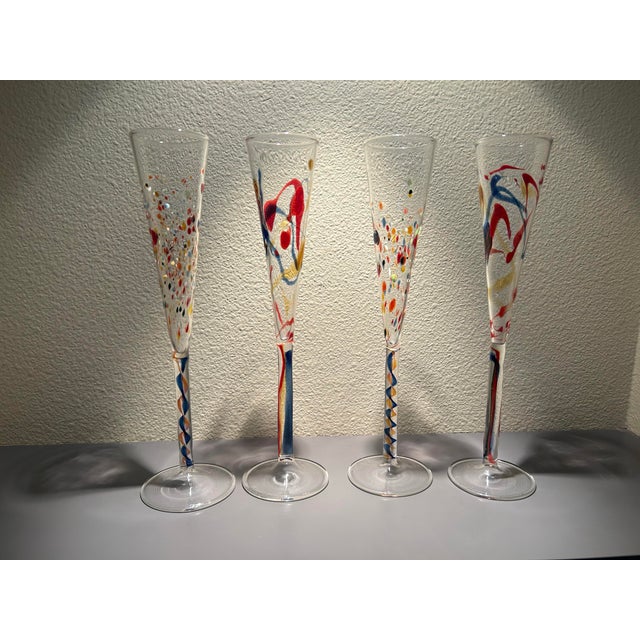 Set of 4 contemporary hand blown art glass champagne flutes with colorful confetti and swirl design. Each glass is unique....
