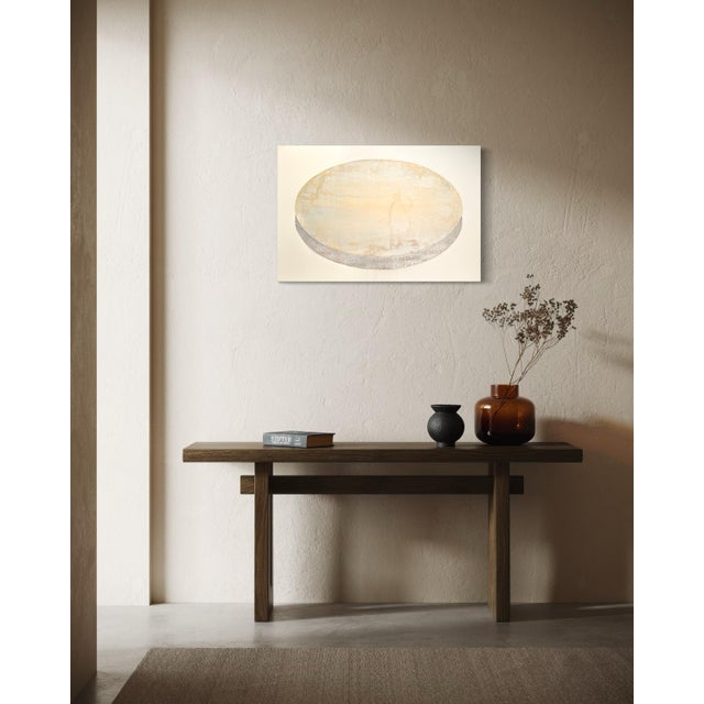 Metal leaf catches the light unevenly across this pearlescent oval, so the surface shifts between warm gold and pale cream...