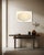 Metal leaf catches the light unevenly across this pearlescent oval, so the surface shifts between warm gold and pale cream...