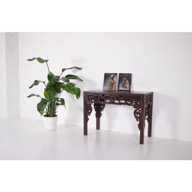 Console carved in solid wood decorated with scrolls. China, end of the qing period, around 1900. Provenance: estate of the...