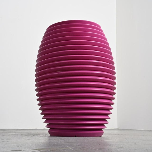 A striking addition to any garden, this tall "Top Pot" planter is made of pink polyethylene. Signed and titled. Stamped...