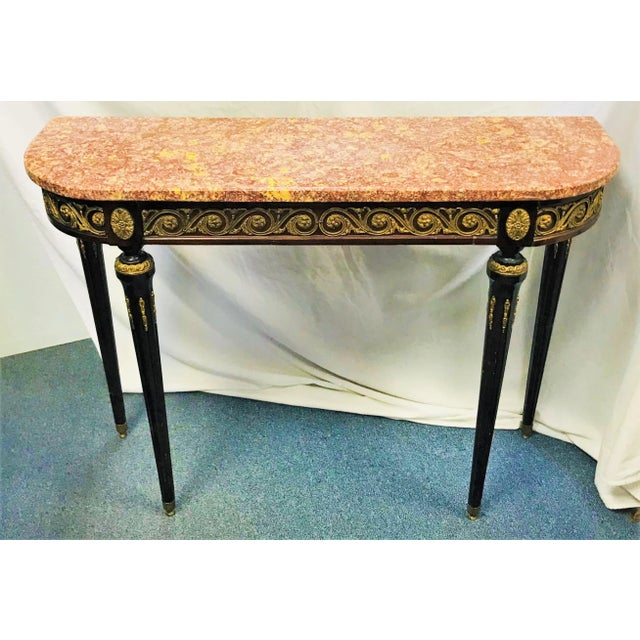 Gorgeous! This 19th century demi-lune table is full of richness. The marble top has lots of movement in deep shades of...