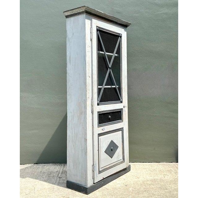 Rich in authentic character and rustic French appeal, this vintage wood and metal cabinet is a striking blend of...