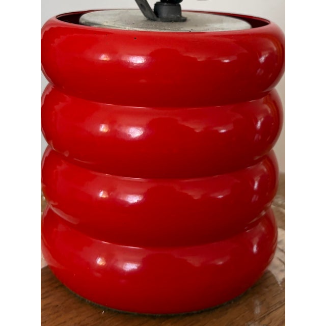 Vintage postmodern table lamp featuring a bold stacked cylindrical base in a vibrant gloss red finish. The playful,...