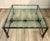 A striking late 20th-century iron and glass coffee table in the manner of Diego Giacometti, featuring a sculptural metal...
